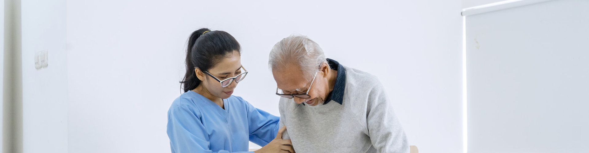 caregiver assist her patient in standing