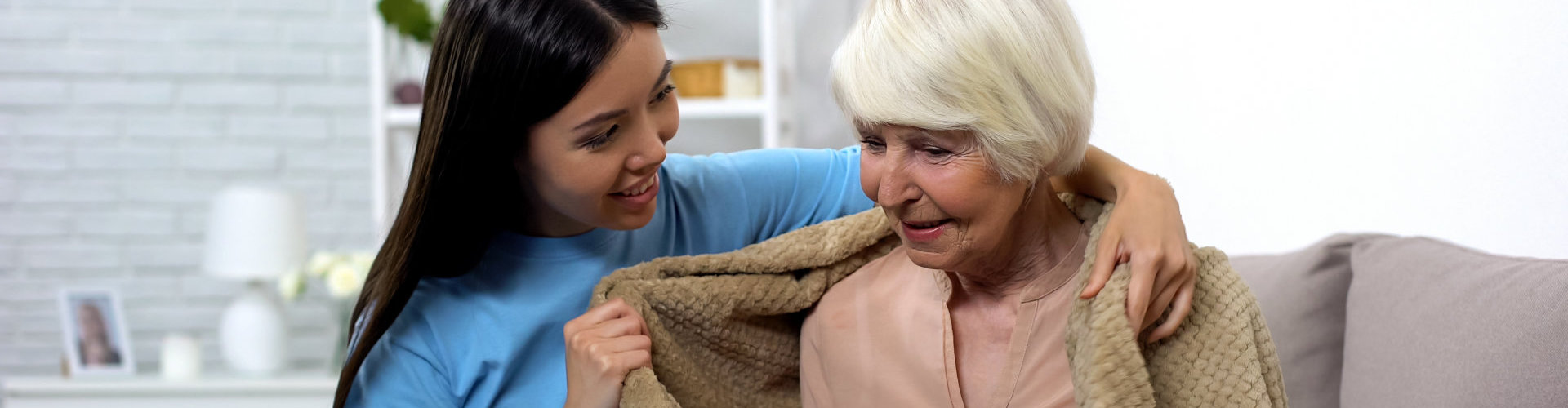 caregiver give her patient a blanket